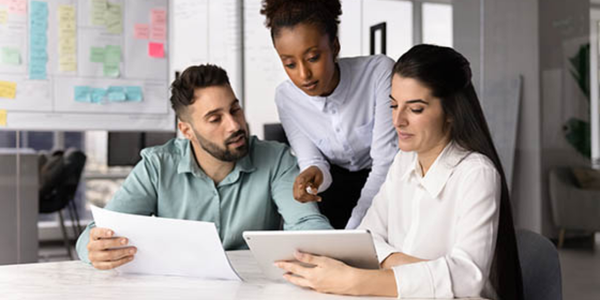 three people sitting in an office together, discussing research credit