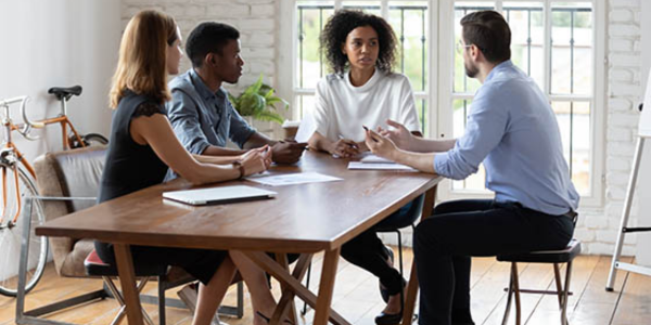 group of people talking at a table about suspected fraud within nonprofit