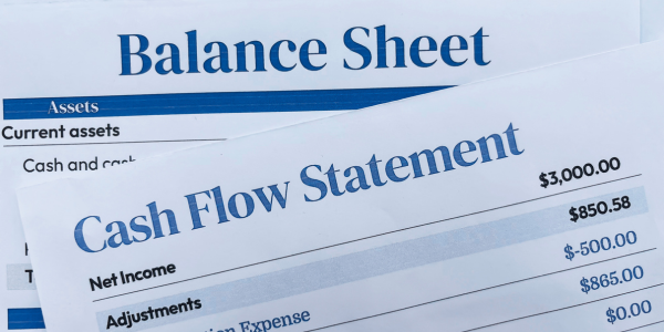 various financial statements stacked on one another including balance sheet and cash flow statement