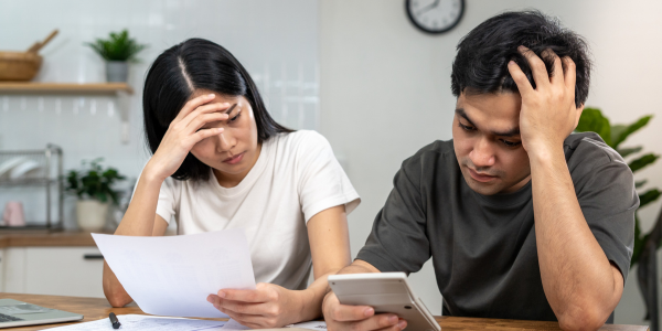 two people sitting at table with calculator and paper, resolving small business tax issues