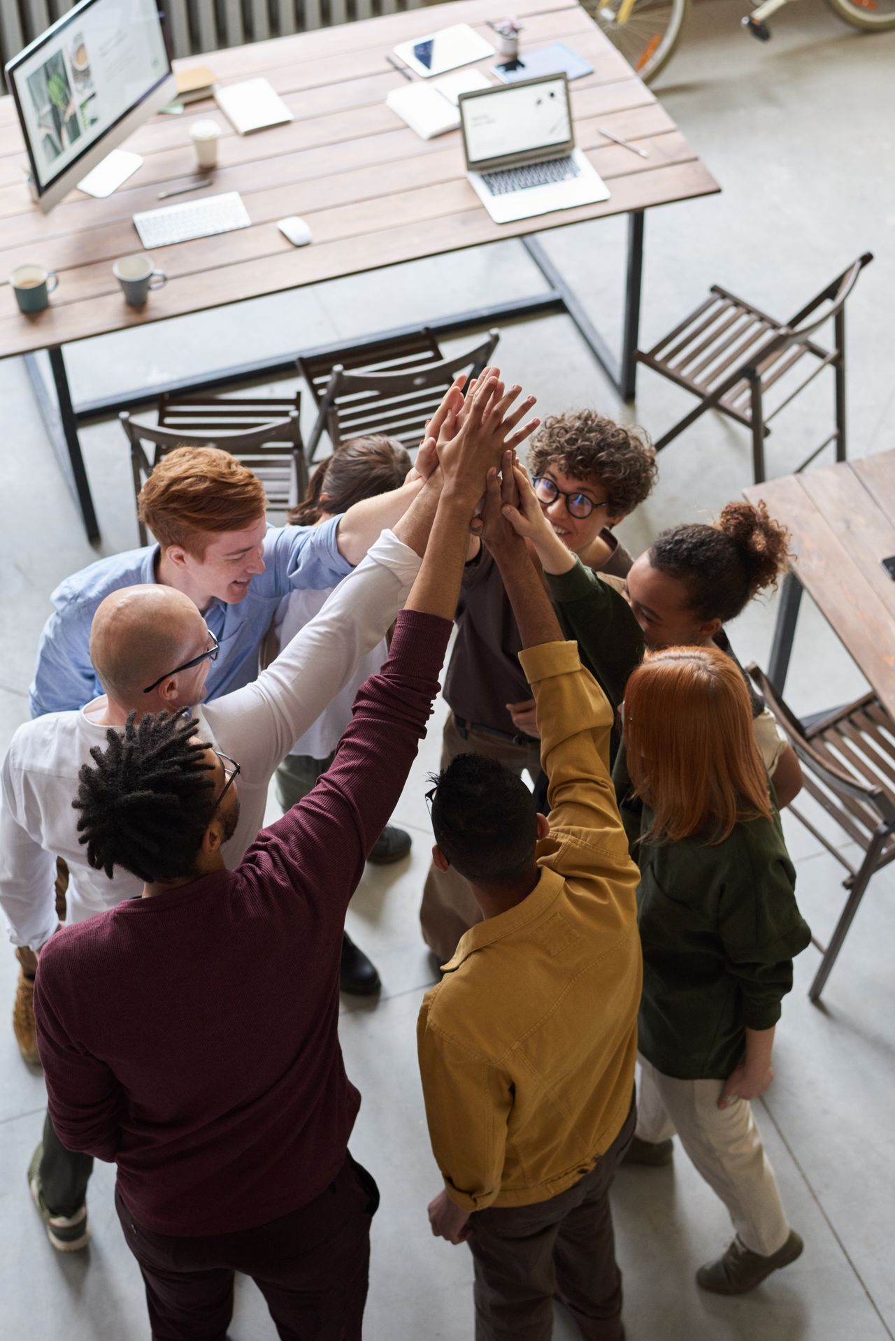 A diverse group of professionals greeting each other in a modern office, demonstrating teamwork and collaboration.