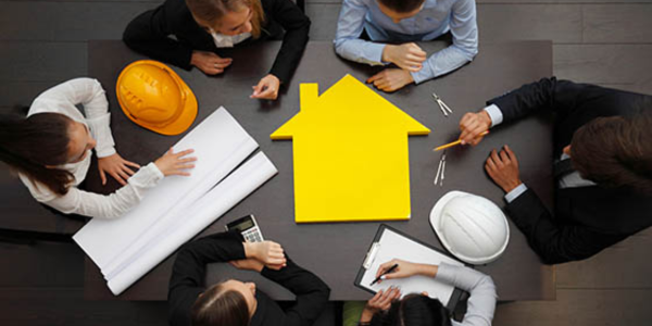 construction contractors and builders meeting at a table with materials on table