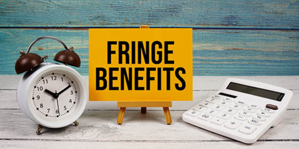 yellow sign that is labeled 'fringe benefits' next to alarm clock and calculator