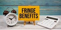 yellow sign that is labeled 'fringe benefits' next to alarm clock and calculator