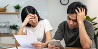 two people sitting at table with calculator and paper, resolving small business tax issues